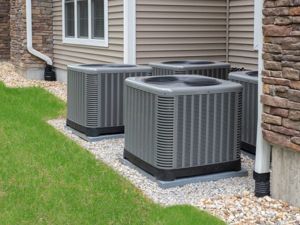 four ac units attached to the outside of a house